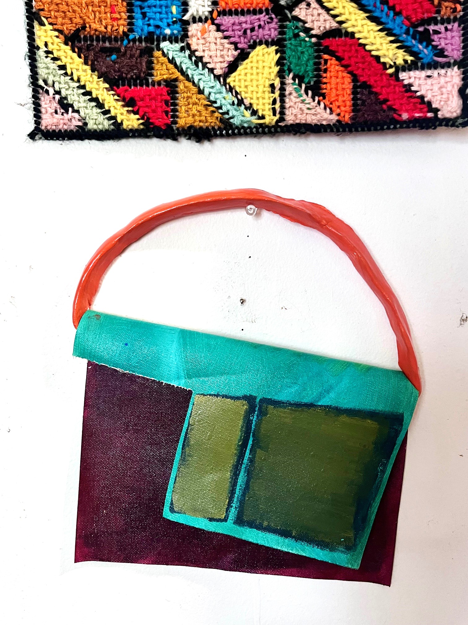 Colorblock flap painting in greens with an orange painted clay hanging